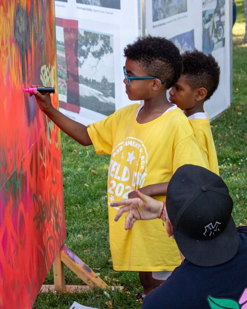 Young artists participating in a live painting activity at the festival – photo by Daniel Seagraves